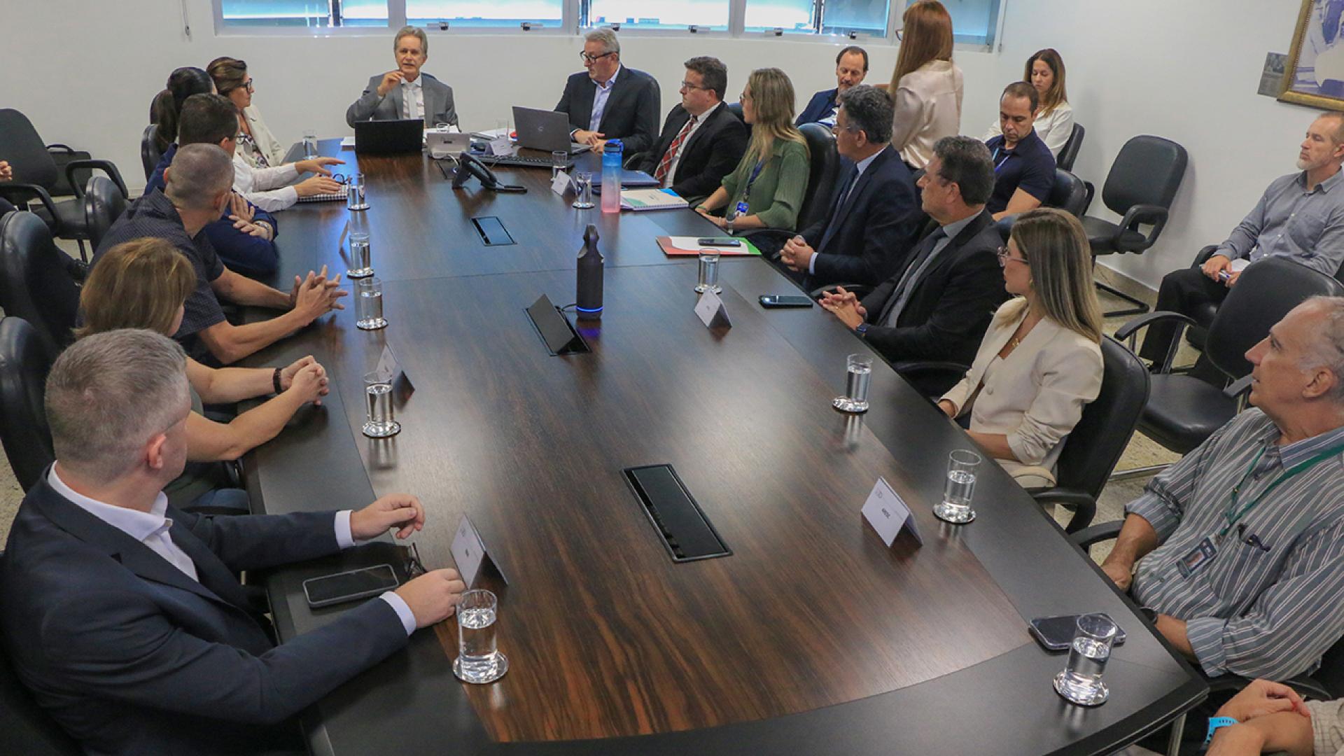 Banner horizontal com foto de reunião da mesa de consensualismo. Há várias pessoas sentadas diante de uma mesa enquanto conversam. Na ponta, o conselheiro Luiz Roberto Herbst. Também presentes o coordenador da mesa, Neimar Paludo, e integrantes do TCE/SC, do IMA, da PMF, da Casan e outras instituições. 