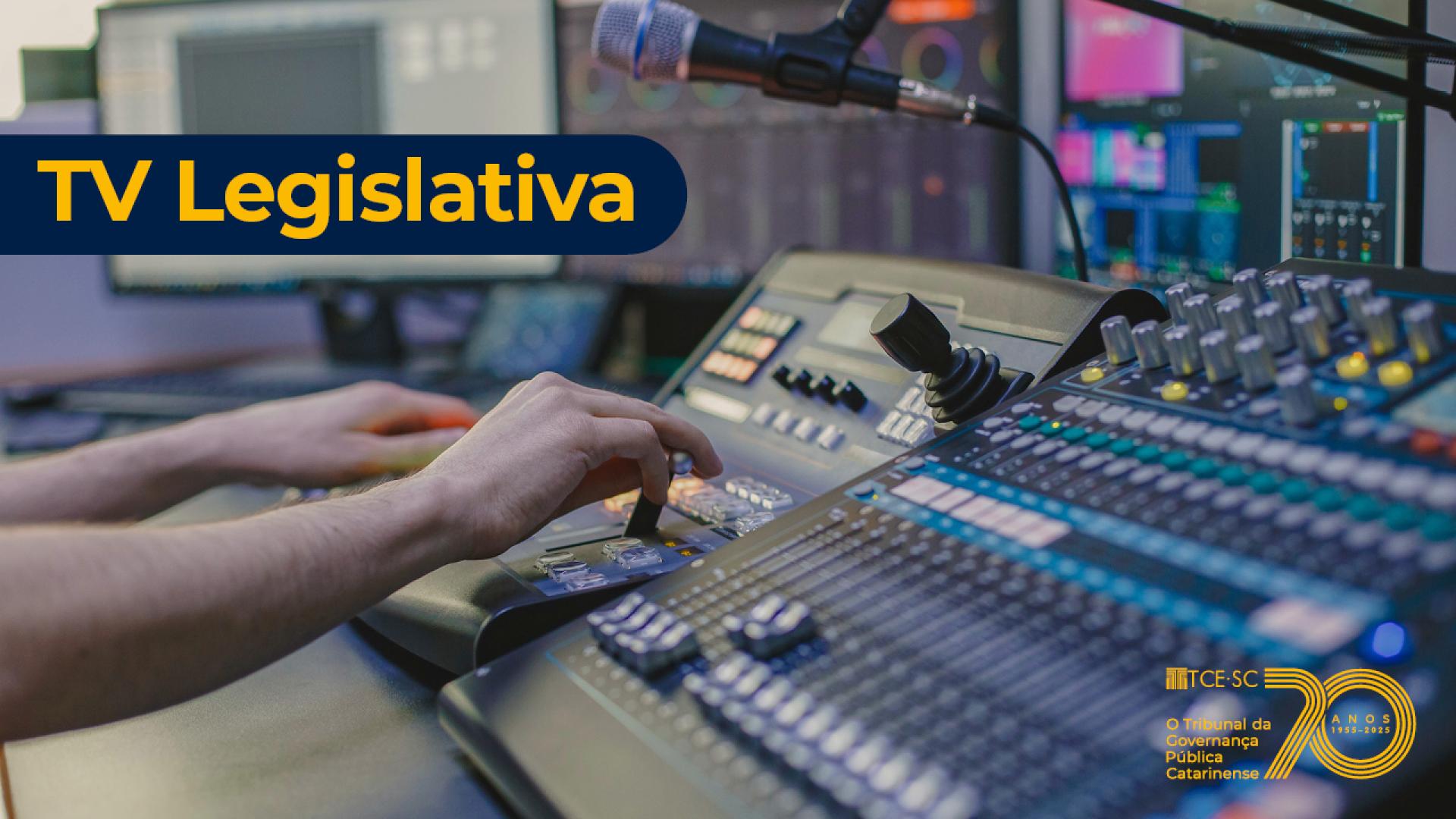 Imagem mostra duas mãos mexendo em uma mesa que tem vários botões. No alto, à esquerda, esta escrito em amarelo TV Legislativa.