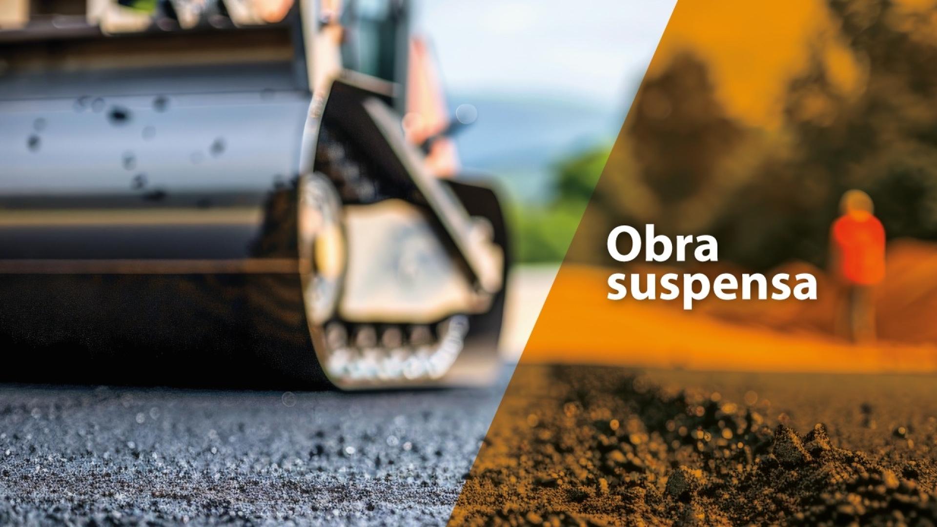 Banner horizontal com foto de uma máquina de pavimentação asfaltando a via. Na lateral direita, sobre tarja vertical laranja, o texto “Obra suspensa”.