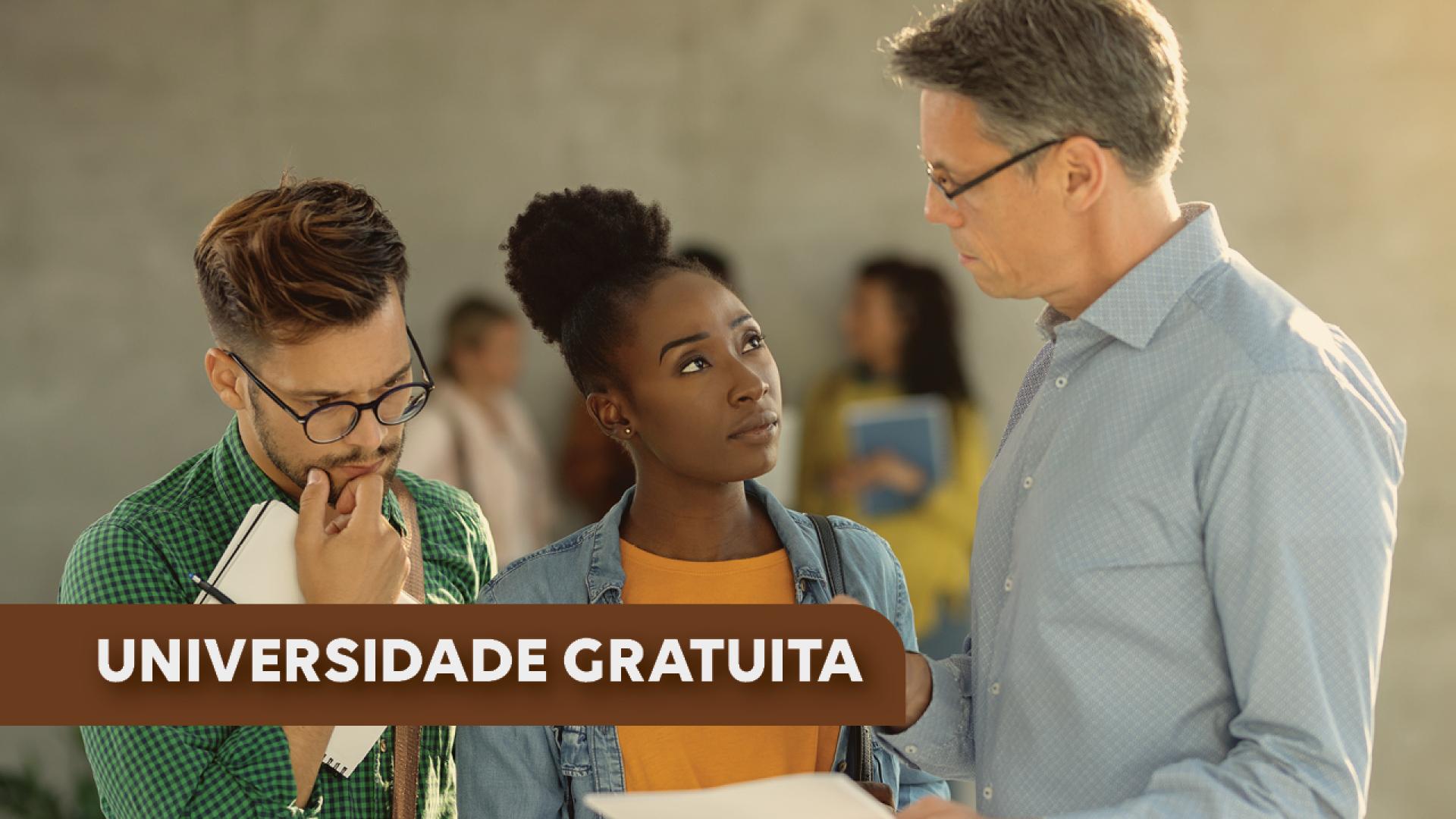 Imagem mostra três pessoas em uma foto. A primeira, à esquerda, é um homem branco de óculos que segura um caderno na mão. A segunda pessoa é uma mulher negra. A terceira pessoa é um homem branco, de óculos, que aparente ser um professor. No canto inferior esquerdo está escrito Universidade Gratuita em branco sobre tarja marrom