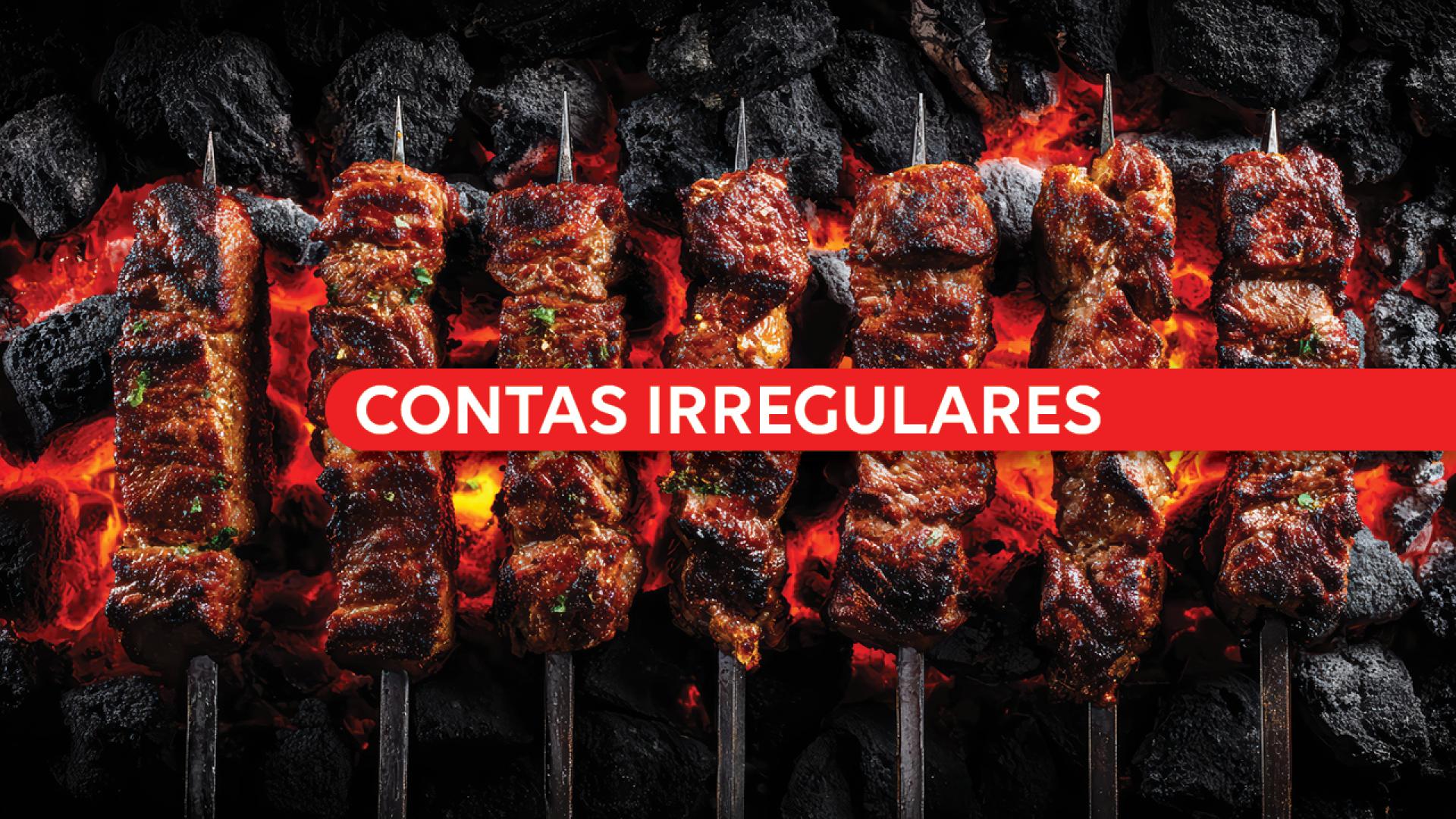 Banner horizontal com foto de vários espetos de carne assando sobre brasas e carvão em brasa, com aspecto dourado. Ao centro da imagem, uma faixa vermelha atravessa horizontalmente os espetos com o texto “Contas irregulares” em letras brancas e destacadas. 