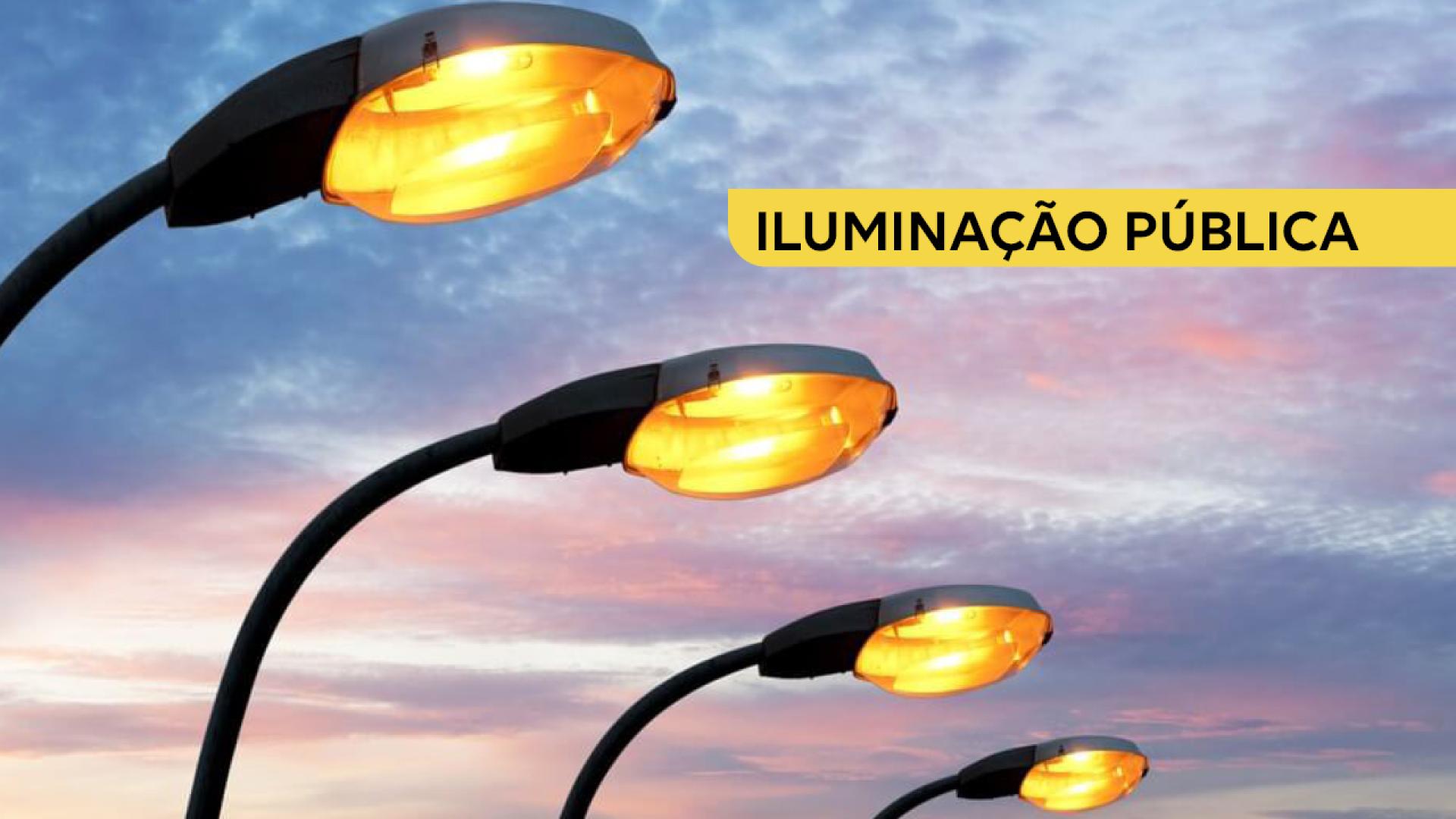 Imagem mostra quatro luminárias de rua em primeiro plano, com luzes acesas. Ao fundo, o céu está maio avermelhado. À direita, no alto, em letra preta sobre tarja amarela, há a inscrição "Iluminação Pública".