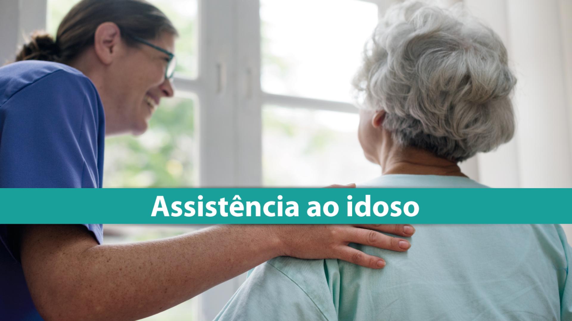 Banner horizontal com imagem de cuidado em ambiente interno. Ao centro, uma profissional de saúde, usando uniforme, conversa e apoia uma pessoa idosa, com a mão sobre seu ombro, em gesto de acolhimento. Ao fundo, há uma janela que ilumina suavemente a cena. Sobre a imagem, uma faixa horizontal em tom verde traz o texto “Assistência ao idoso”. 
