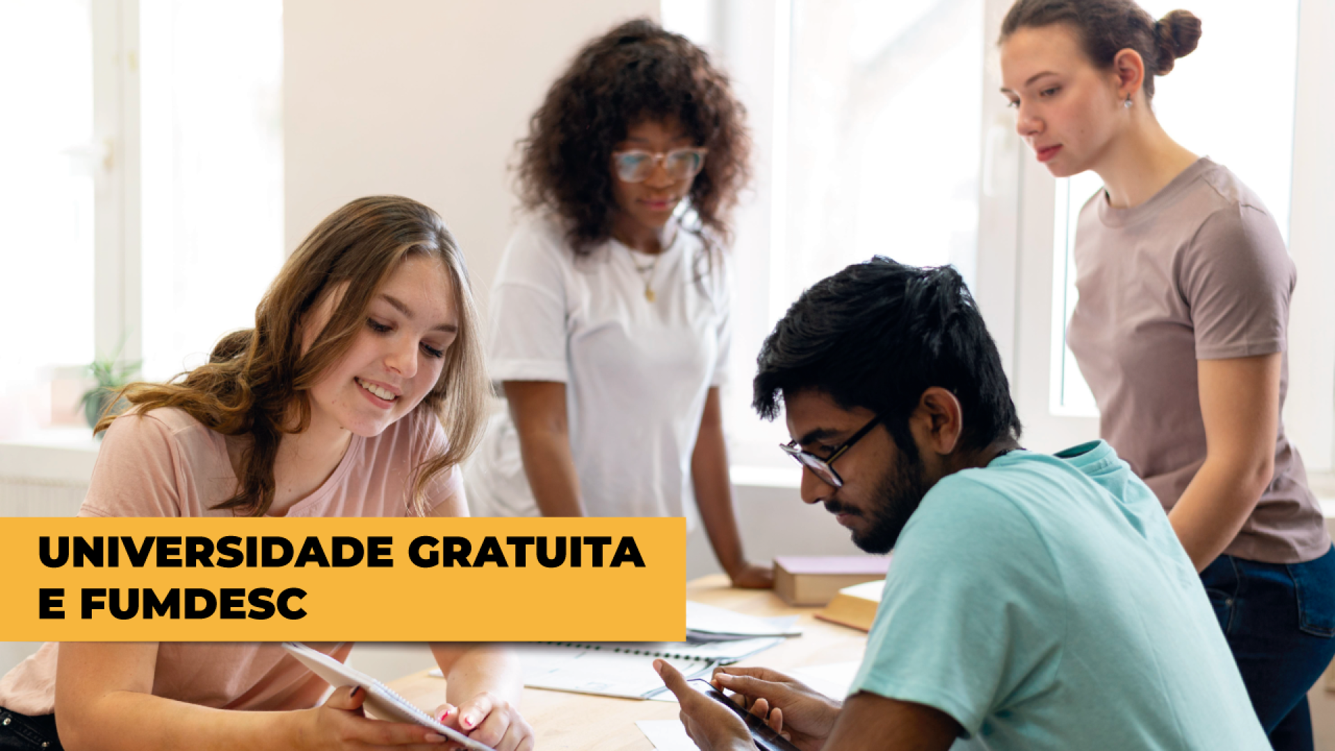 Imagem mostra um grupo de quatro estudantes. No canto inferior esquerdo, escrito em preto sobre fundo alaranjado, está escrito Universidade Gratuita e Fumdesc