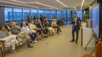 Foto da apresentação dos novos modulos de Processo Eletrônico. À direita, estão algumas pessoas sentadas, entre elas o presidente do TCE/SC, conselheiro Herneus De Nadal, e o conselheiro Wilson Wan-Dall. À esquerda da foto, está o diretor da DTI, Rafael Queiroz em pé apresentando as novas funcionalidades.