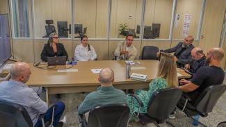 Foto de nove pessoas sentadas diante de uma mesa de reuniões no TCE/SC. Entre os presentes, João Victor Della Rocca, Wallace Pereira, Bianca Tronco e Cilena Guntzel, que ministram a capacitação, e o diretor Moisés Hoegenn. 