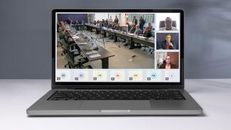 Banner horizontal com foto de um notebook. Na tela, print da reunião realizada. À esquerda, bancada de autoridades. À direita, entre outros, o conselheiro Adircélio de Moraes Ferreira Júnior e o conselheiro Edilson Silva, participando de forma remota.