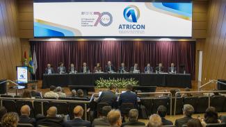 Foto horizontal do auditório bordô do TCE/SC. Na mesa, 10 conselheiros e 1 conselheira. Ao centro, o presidente do TCE/SC,  Herneus De Nadal e ao lado dele o presidente da Atricon Edilson Silva. 