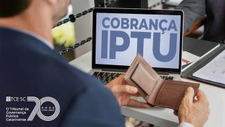 Banner horizontal com foto de um homem, de costas, manuseando uma carteira. Ele está sentado diante de uma mesa sobre a qual está um notebook. Na tela, aparece a inscrição “Cobrança IPTU”. No canto inferior esquerdo do banner, logo comemorativo aos 70 anos do TCE/SC. 