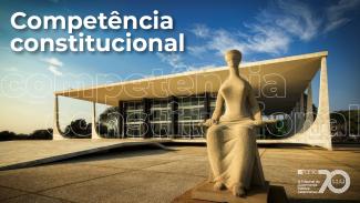 Banner horizontal com foto da fachada do STF, em Brasília. Em primeiro plano, destaca-se a escultura A Justiça, representada por uma figura humana sentada diante do edifício. Ao fundo, aparece a sede do STF, marcada por linhas arquitetônicas modernas, grandes pilares e amplas áreas envidraçadas. No canto superior esquerdo, está o texto “Competência constitucional” em letras brancas. Ao fundo, de forma semitransparente, a expressão se repete como elemento gráfi
