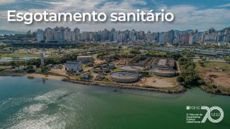Banner horizontal com foto aérea de uma área de tratamento de esgoto localizada às margens de um corpo d’água. Em primeiro plano, aparecem estruturas circulares e instalações de uma estação de tratamento de esgoto. Ao fundo, vê-se a área urbana com prédios residenciais e comerciais. Sobre a imagem, em destaque, está o texto “Esgotamento sanitário”. 