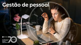 Banner horizontal com foto de uma mulher sentada à mesa, trabalhando em um notebook, segurando um óculos e com expressão concentrada, em um ambiente de escritório com luminária, planta e xícara. Sobre a imagem há o texto “Gestão de pessoal” no canto superior e um efeito gráfico de relógio transparente ao fundo, além do logo do TCE/SC