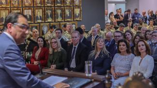 Imagem mostra, em primeiro plano, o presidente do TJ, desembargador Francisco Oliveira Neto, falando ao microfone. Ao fundo, na plateia, sentados, uma série de autoridades, entre elas o presidente do TCE/SC, conselheiro Herneus De Nadal (C) e a vice-governadora Marilisa Boehm