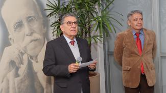 Foto onde aparece ao fundo um painel preto e branco com a imagem de Rui Barbosa. Aparecem duas pessoas na foto: uma delas é o escritor Umberto Grillo e outra é o conselheiro Aderson Flores. Eles participam do lançamento do livro biográfico de Nereu Corrêa na Biblioteca do TCE/SC