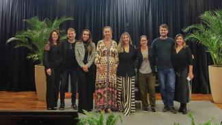 Banner horizontal com foto dos integrantes da Comissão ASG no palco do auditório do TCE/SC. Há oito pessoas, em pé, uma ao lado da outra. Ao centro, a coordenadora da comissão, Marina Ferraz de Miranda.