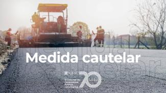 Banner horizontal com foto de uma obra de pavimentação. Em primeiro plano, superfície recém-asfaltada de uma via, enquanto ao fundo aparecem máquinas de construção e trabalhadores atuando no local. Sobre a imagem, em letras brancas, está o texto “Medida cautelar”, acompanhado da marca institucional do TCE/SC. 