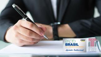 Imagem mostra um homem de casado preto, ao fundo, desfocado, com uma caneta na mão assinando um documento. À direita, no canto inferior, há duas logos. Uma do Pacto Brasil e uma do Tribunal de Contas de Santa Catarina. A do Pacto Brasil tem fundo branco, a palavra “pacto” escrita em verde, letra fina, e a palavra “Brasil” escrita em azul escuro, letras maiores. O logo do TCE é a letra “T” em várias camadas, na cor bordô.