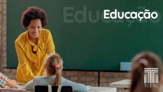 Foto de uma professora, em sala de aula, sorrindo para uma aluna sentada em sua carteira, que está de costas para a foto. Ela é uma mulher negra, de cabelos crespos e curtos. Veste uma blusa amarela. Ao fundo, o quadro de giz. Sobre a foto, no canto superior direito, o texto “Educação”, em fonte branca, e, no canto inferior direito, o logo do TCE/SC. 