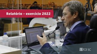 Banner com a foto do conselheiro Ascari na sessão do Pleno. Ele está sentado, de costas. À sua frente, um notebook. Sobre a foto, um retângulo bordô com o texto “Relatório - exercício 2022”.