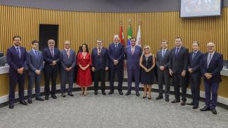 Banner horizontal com foto dos conselheiros e dos homenageados presentes na sessão especial, um ao lado do outro, no plenário do TCE/SC. Há treze pessoas em pé. Entre elas, o presidente do TCE/SC, Herneus De Nadal, e os homenageados, desembargadores Francisco de Oliveira Neto, Maria do Rocio e Altamiro de Oliveira, procurador-geral de Justiça Fábio Trajano e advogada Cláudia Prudêncio.