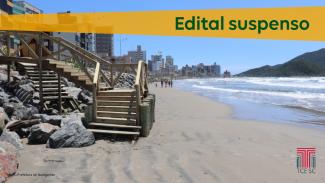 Foto de uma praia. À direita o mar, à esquerda, a faixa de areia e uma escada de madeira, que leva à calçada da rua, em nível superior. Ao fundo, prédios na orla e uma montanha. Sobre a foto, o texto "Edital suspenso" numa faixa laranja. No canto inferior direito, a logo do TCE. No canto inferior direito, o crédito da foto, em fonte pequena: Foto: prefeitura de Navegantes.