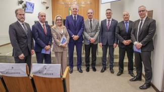 Foto de participantes da reunião dos representantes do Gabinete de Pronta Resposta. Há oito pessoas, uma ao lado da outra, em pé, durante o encontro. Entre os presentes, a presidente do TRE-SC, desembargadora Maria do Rocio Luz Santa Ritta, e o representante do TCE/SC, Sidney Antonio Tavares Júnior.