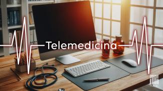 Imagem mostra uma mesa de madeira com um computador sobre ela. No centro, em grafismo que remete a linhas de um eletrocardiograma, está escrito em branco a palavra “telemedicina”