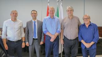 Foto tirada no gabinete da presidente em que aparecem de pé, da esquerda para a direita, o conselheiro substituto Gerson Sicca, o assessor jurídico do TCE/PR Rafael Schuartz, o presidente Herneus de Nadal, o conselheiro do TCE/PR Maurício Requião e o conselheiro Wilson Wan-Dall. 