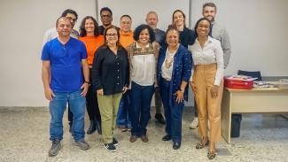 Foto de várias pessoas em pé, uma ao lado da outra, em uma sala de aula, durante o segundo módulo do curso de Letramento Racial. Entre os presentes, a professora Carolina Cavalcanti do Nascimento e membros do TCE/SC. 