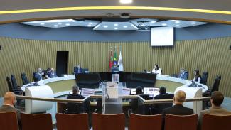 Banner horizontal com foto dos integrantes da Primeira Câmara no Plenário do TCE/SC. Ao centro da bancada circular, o presidente Aderson Flores. Ao redor, entre os presentes, os conselheiros Wilson Wan-Dall e José Nei Ascari, os conselheiros substitutos Gerson Sicca e Sabrina Iocken e o procurador Diogo Ringenberg. 