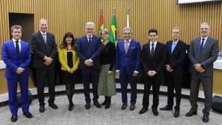 Foto com nove pessoas, em pé, no centro do Plenário do TCE/SC. Da esquerda para a direita: o vice-presidente, José Nei Ascari; o presidente, Herneus De Nadal; a procuradora-geral adjunta do MPTC/SC, Cibelly Farias; o procurador-geral da Procuradoria Jurídica, Loreno Weissheimer, e sua esposa; o conselheiro Aderson Flores; o conselheiro substituto Cleber Muniz Gavi; o conselheiro Luiz Roberto Herbst; e o conselheiro substituto Gerson dos Santos Sicca. 