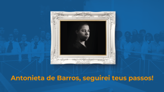 Banner com fundo azul-escuro. Em marca d'água, no fundo, há foto do Coral que interpretou a música no videoclipe. Ao centro, há um quadro, com moldura prata decorada. Antonieta de Barros está na foto, em preto e branco, que está dentro do quadro. Ela é uma mulher negra. Está olhando para a direita. Abaixo do quadro, há o texto “Antonieta de Barros, seguirei teus passos!” em fonte amarela.