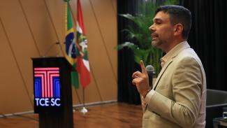 Foto do auditor Fabian Maia palestrando no auditório do TCE SC