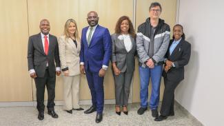 Foto da comitiva do Tribunal angolano na sede do TCE/SC. Há seis pessoas, lado a lado, que vestem trajes formais e sorriem. 