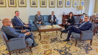 Comitiva brasileira em encontro com a presidente do Tribunal de Contas de Portugal. Há seis pessoas sentadas em sofás enquanto conversam. Entre os presentes, o conselheiro Adircélio de Moraes Ferreira Júnior