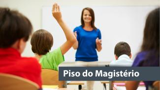 Banner imagem de sala de aula. De frente, professora branca, com cabelos castanhos e blusa azul. De costas 4 crianças, uma delas com a mão levantada. No canto inferior direito o texto Piso do Magistério..