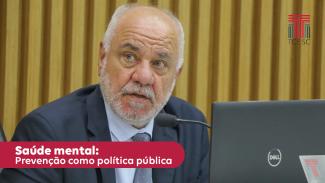 Foto do conselheiro Dado Cherem - homem branco, de cabelos grisalhos.ele veste terno cinza escuro, camisa azul calara e gravata cinza de bolinhas brancas. No canto inferior esquerdo, sobre uma tarja vermelha está escrito em letras brancas "Saúde mental: prevenção como política política"
