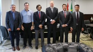 Foto de seis homens em pé, um ao lado do outro, sorrindo para a foto, durante a visita do juiz-conselheiro de Portugal ao TCE/SC. Da esquerda para a direita, o conselheiro Aderson Flores, o conselheiro Adircélio de Moraes Ferreira Júnior, o juiz-conselheiro Luís Miguel, o presidente Herneus De Nadal, o professor André Lupi e o professor Guilherme Reinig. 