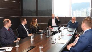 Foto da reunião realizada entre o TCE/SC e o TJSC. Há oito pessoas sentadas ao redor de uma mesa, enquanto conversam. Entre os presentes, o presidente Herneus De Nadal, o conselheiro Luiz Eduardo Cherem e a juíza auxiliar da presidência do TJSC, Maira Salete Meneghetti.