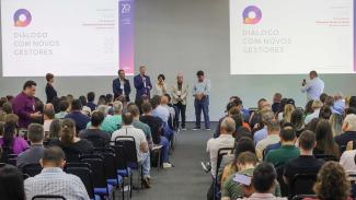 Foto com os participantes do evento, em primeiro plano. Ao fundo, há cinco pessoas, em pé, entre elas o presidente Herneus De Nadal e o diretor do Icon, Moisés Hoeggenn.