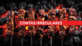 Banner horizontal com foto de vários espetos de carne assando sobre brasas e carvão em brasa, com aspecto dourado. Ao centro da imagem, uma faixa vermelha atravessa horizontalmente os espetos com o texto “Contas irregulares” em letras brancas e destacadas. 