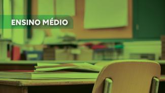 Imagem, com filtro verde, de uma carteira em uma sala de aula. Sobre a mesa, há livros e papéis empilhados. Sobre a foto, na lateral esquerda, em tarja verde, o texto “Ensino médio”, em fonte branca. 