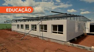Banner horizontal com a imagem de uma escola em construção. Sobre a imagem, na lateral esquerda superior, a palavra “Educação”, em fonte branca e em um retângulo laranja, com a borda direita arredondada. 