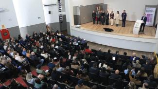 Foto feita do alto mostra pessoas em um palco e a plateia.