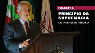 Imagem mostra o jurista Márcio Cammarosano à esquerda, falando ao microfone. Ao fundo, as bandeiras do Brasil, de Santa Catarina e do TCE/SC. à direita, sobre fundo preto, o nome da palestra: "Princípio da Supremacia do Interesse Público"