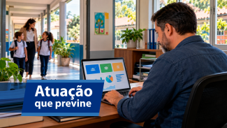 Banner horizontal com foto de homem, de costas, analisando gráficos em um notebook. À sua frente, em um corredor, caminham crianças e uma mulher, juntos. O ambiente é bem iluminado. Sobre a foto, tarja azul com o texto "Atuação que previne".