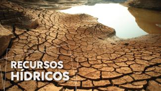 Imagem mostra em primeiro plano um pedaço de terra com rachaduras causadas pela falta de água. Ao fundo há uma poça, passando a ideia de que a quantidade de água está diminuindo. Na parte inferior à esquerda, há a expressão “recursos hídricos”