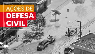 Banner horizontal com imagem aérea, em preto e branco, de um bote salva-vidas entrando em uma rua alagada, sendo puxado por profissionais de resgate. No canto superior esquerdo, sobre tarjas laranja e vermelha, o texto “Ações de Defesa Civil”.  