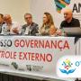 Imagem mostra em primeiro plano uma mesa com faixa onde se lê "Quinto Congresso Governança e Controle Externo". À mesa estão seis pessoas, entre elas o conselheiro do TCE/SC Wilson Wan-Dall, que fala ao microfone